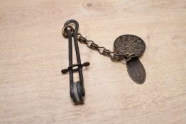 A fine Victorian metal ladies skirt lifter, featuring a circular clamping mechanism decorated with