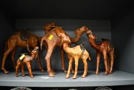 A selection of 20th-century Liberty-style leather camel figurines, featuring hand stitched saddles