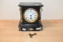 A Victorian black slate and marble mantel clock, of architectural style, having twin columns upon