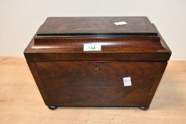 A 19th century mahogany tea caddy, of sarcophagus form, the hinged top lifting to reveal the three