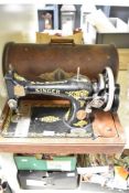 An oak cased hand-cranked Singer sewing machine, of traditional design