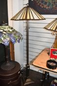 A tall contemporary Tiffany-style standard lamp, featuring a panelled Art Deco-style shade with twin