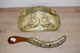 A late 19th-century Art Nouveau-style brass brush crumb tray, featuring an embossed design of two