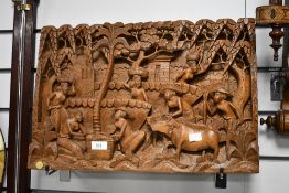 A vintage Balinese-style carved wooden wall panel, depicting a traditional agrarian scene,