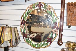 A contemporary Tiffany-style wall mirror, featuring a delicate magenta floral and green foliate