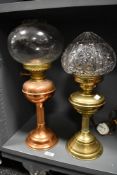 Two late 19th to early 20th-century oil lamps, to feature a converted brass example with a crystal