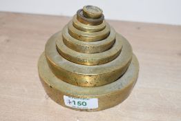 A set of eight cast brass graduating/nesting weights, 1/2 Oz - 4lb, one weight (1oz) possibly
