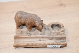 An early 20th-century Black Forest-style carved wooden bear inkwell with pen tray, featuring a