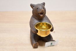 A sweet early to mid 20th-century Black Forest carved oak bear, featuring a removable brass bowl and