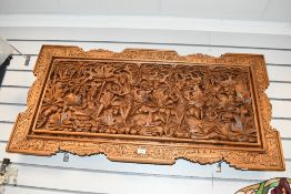 A large vintage Balinese-style carved wooden wall panel, depicting a traditional floral, foliate and