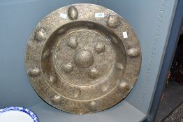 A large 20th-century Middle Eastern-style brass charger, featuring elaborate engraved foliate and