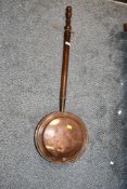 A 19th-century copper bed warming pan, having a smooth turned wood handle, unmarked, approximately