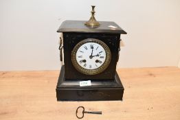 A Victorian black slate mantel clock, having a knopped gilt metal finial top over an enamelled dial