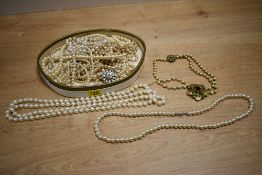 An assortment of faux pearl necklaces, of cream and white colour, some with paste set clasps