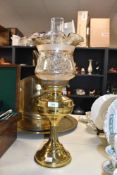 A 20th century brass oil lamp of traditional form with disc adjusters, acid etched shade and clear