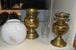 Two late 19th to early 20th-century duplex brass oil lamps, both having glass chimneys; sold with