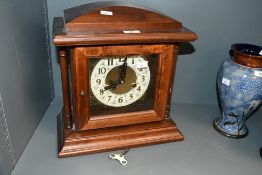 A 20th-century Howard Miller-style windsor cherry-finish mantel clock, featuring an 8-day key-