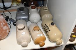 Five early to mid 20th-century stoneware bed warmers; sold with a metal example, some marked but not