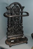 A Victorian cast iron umbrella stand, with an intricate pierced back panel of scrolled foliate and
