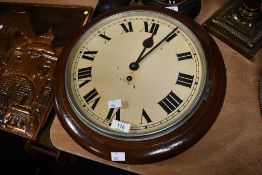 An early to mid 20th-century circular oak station-style wall clock, having Roman hours upon a