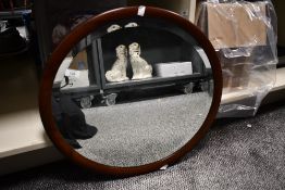 An early to mid 20th-century oval mahogany framed mirror, unmarked but with hanging fixtures to