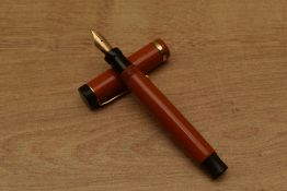 A Parker Junior Duofold Lucky Curve button fill fountain pen in Red with single cap band having