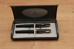 Two Parker Sonnet converter fill fountain pens. O in Matte Black with Gold trim having Parker nib,
