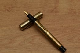 A Burnham lever fill fountain pen in gold plated wave pattern having Burnham 14ct nib. Circa 1926.