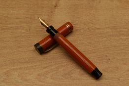 A Parker Duofold Special Streamlined button fill fountain pen in Red with two narrow cap bands