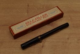 A boxed 'Self Filler' lever fill fountain pen in black with two cap bands having a Warranted 14CT