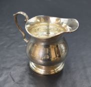 An Elizabeth II silver jug, of bulbous form having a generous spout opposed by a scroll handle,