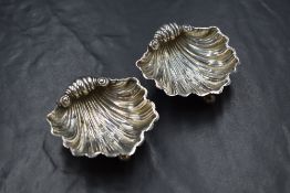 A pair of late Victorian silver salts, of shell form raised on three ball feet, marks for Birmingham