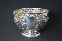 An Edwardian silver rose bowl, of traditional form having decorative floral swags, raised on a