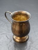 An Elizabeth II silver cup, of bulbous form having a c-curve handle with 'E.LH.', raised on a