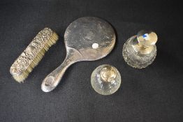 A George V silver hand mirror having planished decoration, dented in areas sold alongside a silver