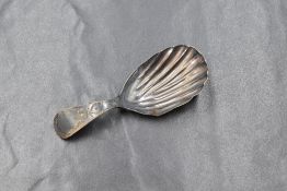 A George III silver caddy spoon, of traditional form having a scalloped bowl and bright-cut style