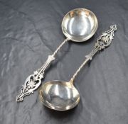 A cased pair of Edwardian silver serving spoons having decorative pierced floral terminals on