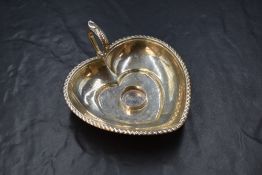 A Victorian silver chamberstick holder, of heart form having a gadrooned rim with scroll handle,