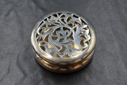 An Edwardian silver pot pourri box, of circular form having a decorative pierced floral top, marks