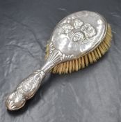 An Edwardian silver mounted hair brush, having cherubs to the centre with scroll decoration and