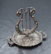 An Edwardian silver jewellery stand, in the form of a harp having hooks to the body, raised over