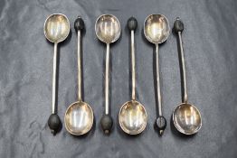 A cased set of George V silver coffee bean spoons, having black 'beans' to terminals, marks for