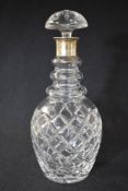 A 20th century silver mounted glass decanter, the flared silver top over a step moulded neck and