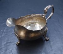 A George IV silver sauce boat, having a Chippendale style rim with a generous spout opposed by a