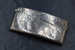 A late Victorian silver card holder, of hinged rectangular form and curved for the pocket, having