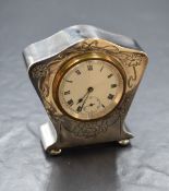 An early 20th century silver vanity clock, having decorative floral swag engraving to the front,