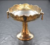An Edwardian silver pedestal bon-bon dish having a scroll rim and angular handles, raised on a