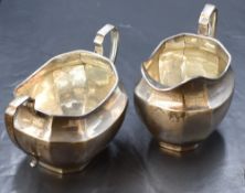A late Edwardian silver sugar and cream, of oval form having canted sides and angular handles, marks