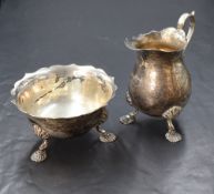 An Elizabeth II silver sugar and cream, having Chippendale style rims raised on three cabriole style