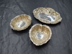 A group of three Elizabeth II silver pin dishes, two of oval form and one in a heart motif, all
